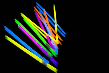 Renkli floresan ışık neon kızdırma ayna yansıması siyah arka plan üzerinde sopa. Sarı mavi pembe turuncu yeşil mor kızdırma sopa