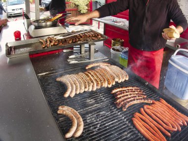 Taze et ızgara sosis merguez yumurcaklar kızartma, Barbekü piknik sandviç saklamak açık el Ocak adamla büyük ızgara