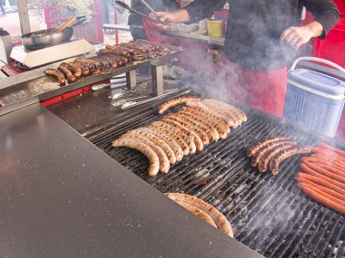 Taze et ızgara sosis merguez yumurcaklar kızartma, Barbekü piknik sandviç saklamak açık el Ocak adamla büyük ızgara
