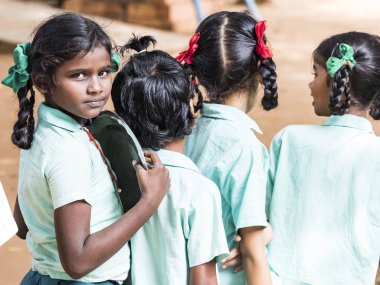 Puducherry, Tamil Nadu, Hindistan - Aralık yaklaşık, 2018. Yemeden önce kuyu onların plaka temizlemek için tanımlanamayan zavallı sınıf çocuklarla üniformalar kuyruk açık havada. Öğle yemeği zamanı, genel hükümet okulda sağlıksız gıda