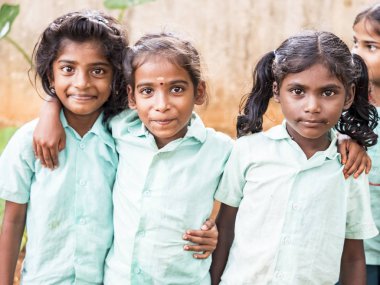 Puducherry, Hindistan - Aralık yaklaşık, 2018. Kimliği belirsiz en iyi çocuk kız arkadaş sınıf ile ayakta gülümseyen hükümet okul üniformalı omzuna elini. Dostluk zevk çok ırklı schoolchilds portresi.
