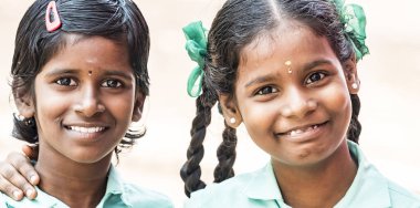 Puducherry, Hindistan - Aralık yaklaşık, 2018. Kimliği belirsiz en iyi çocuk kız arkadaş sınıf ile ayakta gülümseyen hükümet okul üniformalı omzuna elini. Dostluk zevk çok ırklı schoolchilds portresi.