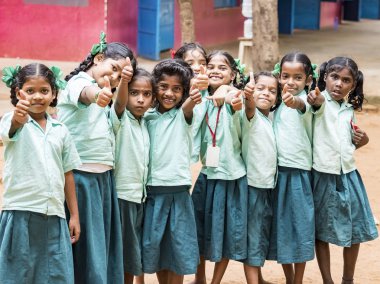 Puducherry, Hindistan - Aralık yaklaşık, 2018. Kimliği belirsiz mutlu en iyi çocuk kız arkadaş sınıf arkadaşları hükümet okul üniformaları jest gösteren başparmak gülümseyerek. Dostluk duygu zevk okul Childs'ın portresi.