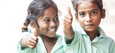 Puducherry, Hindistan - Aralık yaklaşık, 2018. Kimliği belirsiz mutlu en iyi çocuk kız arkadaş sınıf arkadaşları hükümet okul üniformaları jest gösteren başparmak gülümseyerek. Dostluk duygu zevk okul Childs'ın portresi.