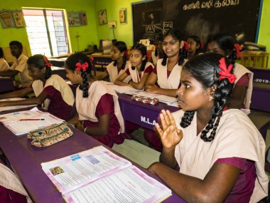 PUDUCHERRY, İNDİA - Aralık 2018. Devlet okulunda üniformalı tanımlanamayan mutlu sınıf arkadaşları evde oturup kitap okuyor. Fakir gençlerin okul portresi arkadaşlığın keyfini çıkarıyor..