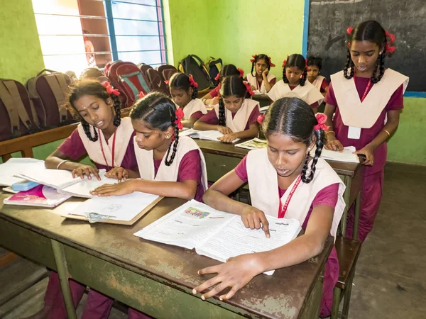 PUDUCHERRY, İNDİA - Aralık 2018. Devlet okulunda üniformalı tanımlanamayan mutlu sınıf arkadaşları evde oturup kitap okuyor. Fakir gençlerin okul portresi arkadaşlığın keyfini çıkarıyor..