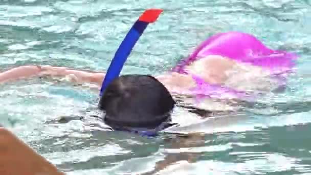 プールでスイミング マスク身に着けているティーンエイ ジャー 幸せな休日のコンセプトです かわいい幸せの少し泳いでいる少年と Snorking 結晶の海海の青い水 — ストック動画