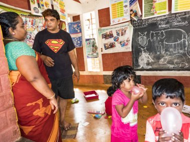 Puduchery, Hindistan - Aralık yaklaşık, 2018. Zavallı okul öncesi öğretmeni ve grubu çocuklar çocuklar kız okulda sadece birkaç ahşap oyuncak oyunları ile şaka yapıyordum. Okulda yoksulluk