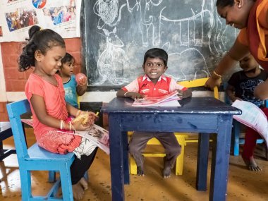 Puduchery, Hindistan - Aralık yaklaşık, 2018. Zavallı okul öncesi öğretmeni ve grubu çocuklar çocuklar kız okulda sadece birkaç ahşap oyuncak oyunları ile şaka yapıyordum. Okulda yoksulluk