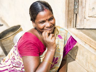 Puduchery, Hindistan - Aralık yaklaşık, 2018. Bir mutlu gülümseyen olgun Hintli kadın kameraya bakarak çene üzerinde el ile tanımlanamayan portresi. Sokak köyde kahverengi saçlı güzel Asyalı kadın yüzü yukarı kapatın