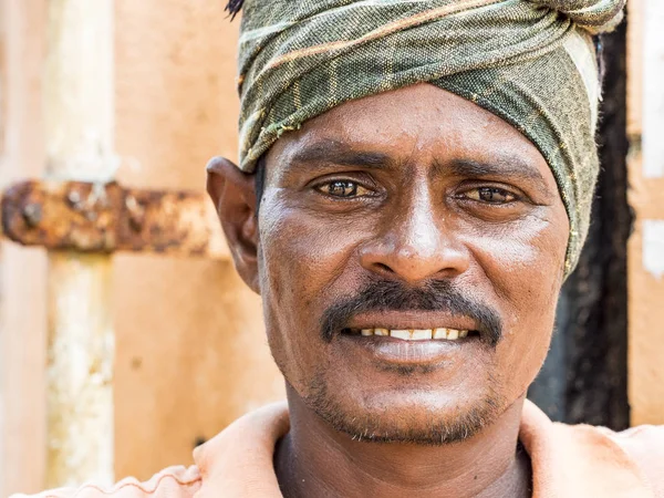 Puduchery, Hindistan - Aralık yaklaşık, 2018. Kimliği belirsiz Hint alt turuncu arka plan ile küçük bir köy kamerada bakarak turuncu elbise ile portresi. Hindistan'ın kırsal insanlar günlük yaşam.