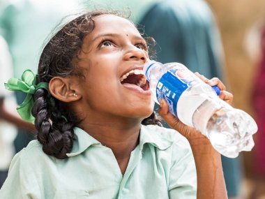 Puduchery, Hindistan - Aralık yaklaşık, 2018. İçme suyu tanımlanamayan yakışıklı tatlı gülümseyen Hintli kız açık havada, portresi. Yoksul insanların olsalar bile neşeli kavramı.