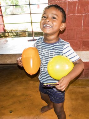 Puduchery, Hindistan - Aralık yaklaşık, 2018. Gülümseyen ve kreş balonunda oynamaktan tanımlanamayan zavallı Hint küçük çocuk