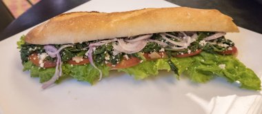 Fransız baget sandviç soğan peynir domates ve ıspanak, beyaz tabakta kapatın. Afiş panoramik boyutu