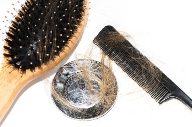 Saç dökülmesi lavabo üzerinde. Uzun kahverengi saçlı siyah tarak ve beyaz Havzası Banyo üzerinde ahşap fırça ile. Sağlık kavramı