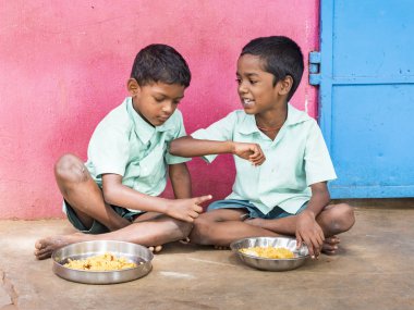 İki erkek gençler öğrenciler kamu okulu kantin pirinç yemek tabağı servis ediliyor. Yoksul çocuklar için sağlıksız gıda