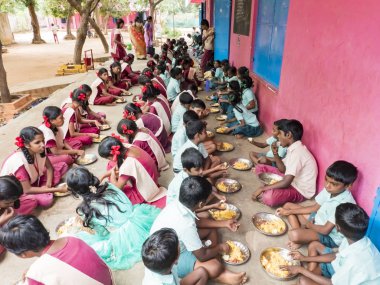 Genç öğrenciler grubu hizmet vermektedir kamu okul kantini pirinç yemek tabağı. Yoksul çocuklar için sağlıksız gıda
