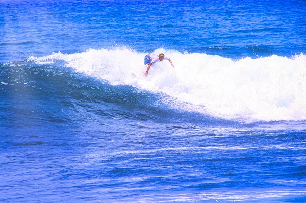 Un uomo che cattura un'onda oceanica vicino alla costa. Sport acquatici estremi e stile di vita attivo all'aperto. Con spazio per la copia del testo. - Immagine — Foto Stock