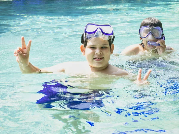 Vacaciones de verano y el concepto de adolescente - primer plano de hermanos manos mostrando v-signo con los dedos en el océano agua transparente . —  Fotos de Stock