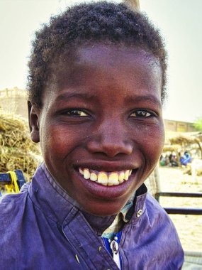Unidentified Malian boy smiles and poses in the street in Timbuktu. Children of Africa suffer of poverty due to the unstable economic situation clipart