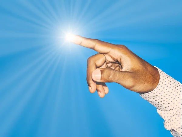 Close up of a young indian man hand pointing finger as touching screen, with light ray, isolated on blue background.