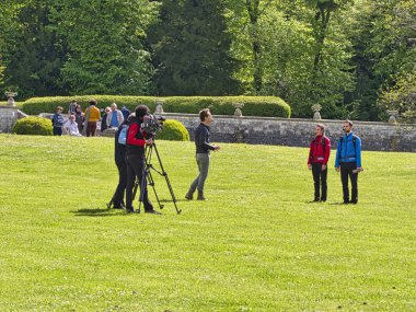 Yüksek çözünürlüklü dijital video kameranın görüş açısı hangi kayıt veya tv ticari üretim pan tilt üst karakter kümesiyle açık konumu ve film ekibi takım'deki profesyonel baş tripod üzerinde çekim geri.