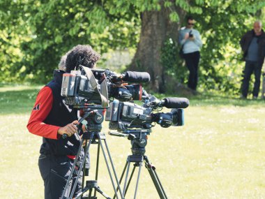 Açık konumda pan tilt shift profesyonel baş tripod üzerinde kayıt veya çekim tv ticari üretim yüksek çözünürlüklü dijital video kamera ön açı görünümü.