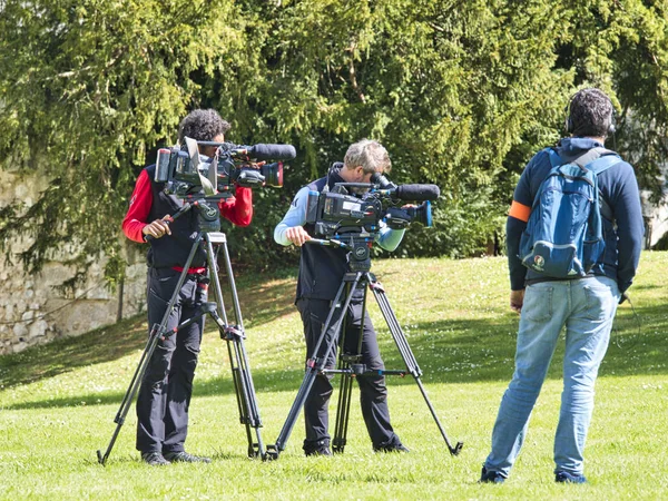 Widok z przodu kąt wysokiej rozdzielczości cyfrowej kamery wideo, które nagrywania lub fotografowania telewizji komercyjnej produkcji na Pan Tilt Shift profesjonalny statyw głowy w miejscu na zewnątrz i zespół załogi filmowej z zestawem — Zdjęcie stockowe