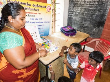 Zavallı devlet okul öncesi öğretmeni ve çocukların ellerini kaldırarak ve okulda biraz eğlenmek onun grubu