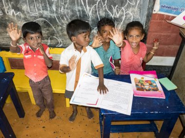 Sevimli zavallı küçük çocuk, erkek kızlar, masada sandalyede oturan, kitap okumaya çalışıyor