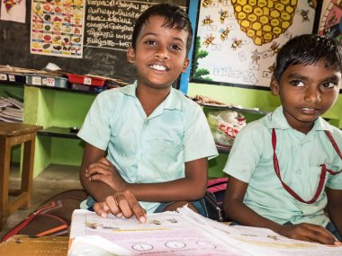 Çocuklar grup arkadaş sınıf arkadaşları okulda sandalyelerde oturan kitap ile okuyor. Dostluk zevk okul çocuklar