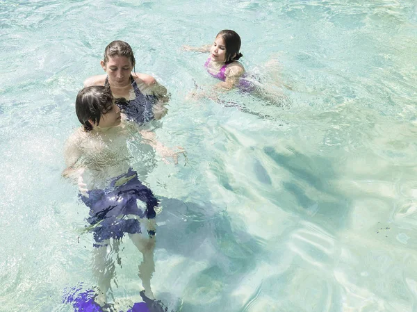 Familia feliz en trajes de baño en la piscina en el complejo parque acuático — Foto de Stock