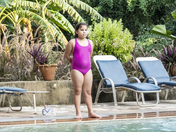 Feliz adolescente chica está saltando en la piscina infinita en el complejo — Foto de Stock