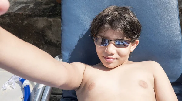Adolescent fericit în ochelari de soare culcat pe baie de soare și de a lua selfie la vară — Fotografie, imagine de stoc