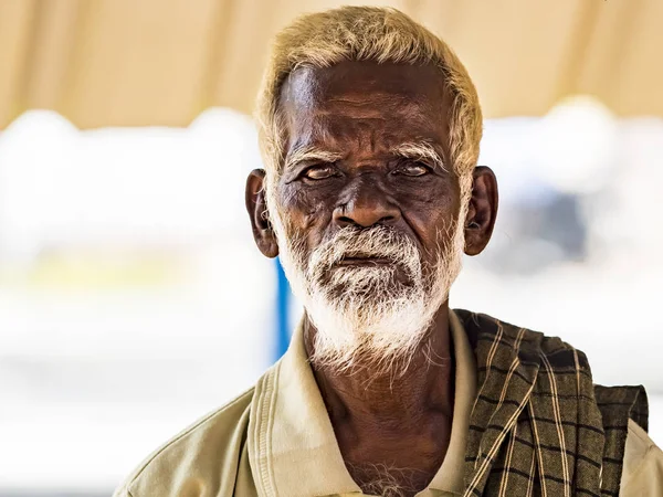 Un viejo indio indio pobre retrato sin identificar con una cara arrugada de color marrón oscuro y pelo blanco y una barba blanca, parece serio — Foto de Stock