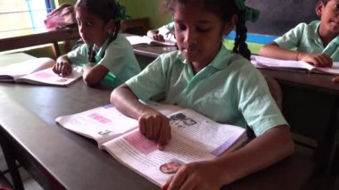 Puducherry, Tamil Nadu, Hindistan - Aralık 2018. Tanımlanamayan yoksul Hintli öğrenci. Yerel bir devlet okulunda üniformalı. Öğretmeniyle İngilizce öğreniyor..