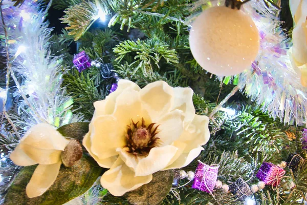 Julgran med rödlila och vita leksaker och blommor i inredningen. — Stockfoto