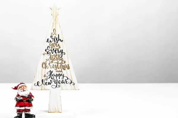 Beautiful Minimal Christmas wood tree with Merry Christmass and happy new year written, with small Santa Claus, on white backgound — Stock Photo, Image