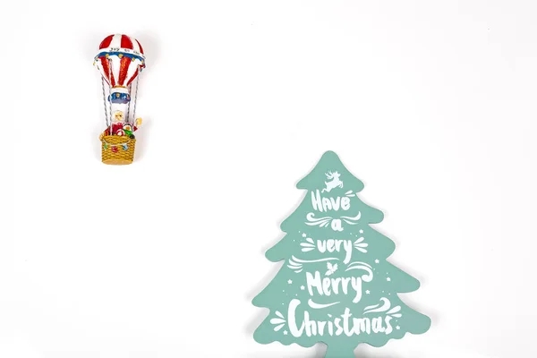 Santa Claus in Hot air balloon flight up to a wood green tree, on white background — Stock Photo, Image