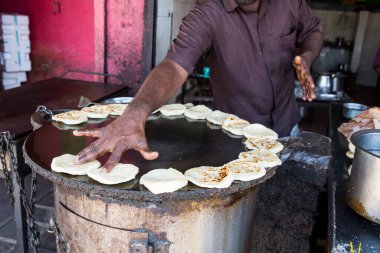 PONDICERRY, İNDİYA - Aralık 2019, Circa. Restoranda öğle ve akşam yemeği için parotta ekmeği yapan kimliği belirsiz bir adam. Pişirmek için farklı bir adım..