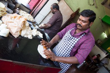 PONDICERRY, İNDİYA - Aralık 2019, Circa. Restoranda öğle ve akşam yemeği için parotta ekmeği yapan kimliği belirsiz bir adam. Pişirmek için farklı bir adım..