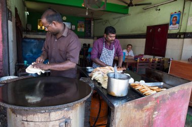 PONDICERRY, İNDİYA - Aralık 2019, Circa. Restoranda öğle ve akşam yemeği için parotta ekmeği yapan kimliği belirsiz bir adam. Pişirmek için farklı bir adım..