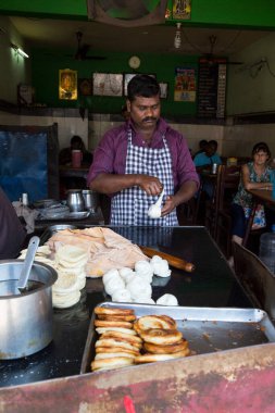 PONDICERRY, İNDİYA - Aralık 2019, Circa. Restoranda öğle ve akşam yemeği için parotta ekmeği yapan kimliği belirsiz bir adam. Pişirmek için farklı bir adım..