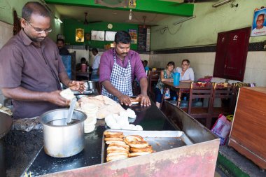 PONDICERRY, İNDİYA - Aralık 2019, Circa. Restoranda öğle ve akşam yemeği için parotta ekmeği yapan kimliği belirsiz bir adam. Pişirmek için farklı bir adım..