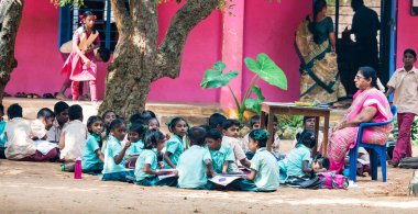 PUDUCHERRY, İNDİA - Aralık 2018. Kimliği belirsiz bir grup çocuk kız arkadaş devlet okulu üniformalı sınıf arkadaşları yerde oturup dışarıda kitaplarla çalışıyorlar..