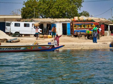 SENEGAL, AFRICA - MARSCH Circa, 2016. Nehirde sahne hayatı. Teknesi ve renkli evleri olan bir balıkçı. Canlı renkler