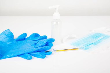 Mavi eldivenler beyaz arka planda el jeli maske termometresi. Coronavirüs dünya pandemisini durdurmak için her gidişinizde kullanacağınız set. Boşluğu kopyala