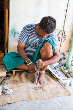 Hintli heykeltıraş, küçük Ganesh heykeli oyuyor.