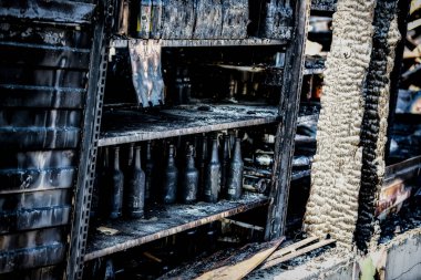Hasarlı süpermarket cam plastik şişelerini kundaklama olayından sonra yoğun yangın felaketinin ardından yanan siyah molozlarla kapatıyoruz. Sigorta araştırması için bekleyen harabeler. Doymuş karşıtlık etkisi dramatik atmosfer