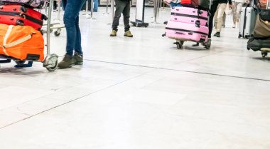 Seyahat valizli birkaç gezgin, tatil amaçlı iş seyahati konsepti için havaalanı terminali koridorunda yürüyor. Koronavirüs sırasında sosyal mesafeler. Fransa, Paris